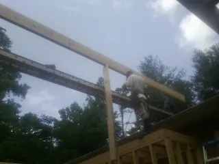 Carpenter setting a ridge beam over a new addition frame — Ice Dam Removal by Roofing Brothers in Port Hadlock